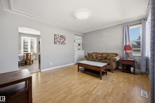 Living area featuring laminate floors and built-in wall unit. - 4209 116 Avenue, Edmonton, AB - Indoor
