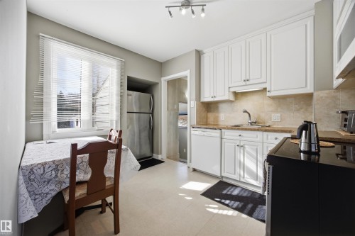 Kitchen with white cabinets, freestanding refrigerator, light colored countertops, dishwasher, and tasteful backsplash - 4209 116 Avenue, Edmonton, AB - Indoor Photo Showing Kitchen