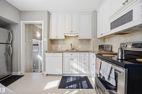 Kitchen with stainless steel appliances, light colored counters, white cabinets, and tasteful backsplash - 4209 116 Avenue, Edmonton, AB - Indoor Photo Showing Kitchen