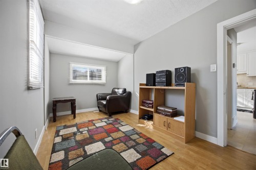 South-facing Bedroom with light laminate flooring and baseboards. - 4209 116 Avenue, Edmonton, AB - Indoor