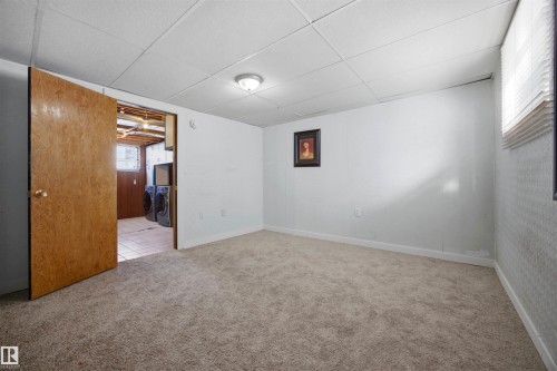 Basement spare room with carpet flooring, a paneled ceiling, and wallpapered walls - 4209 116 Avenue, Edmonton, AB - Indoor Photo Showing Other Room