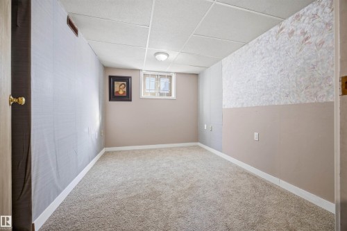 Basement bedroom with carpet flooring, a paneled ceiling, and wallpapered walls - 4209 116 Avenue, Edmonton, AB - Indoor Photo Showing Other Room