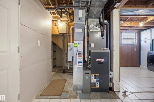 Utility room featuring a high-efficiency furnace with A/C, and instant hot water tank - 4209 116 Avenue, Edmonton, AB - Indoor Photo Showing Basement