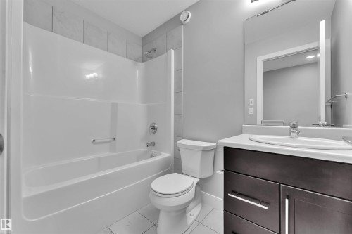 Bathroom with vanity, bathing tub / shower combination, and light tile patterned floors - #38 1508 105 St Nw, Edmonton, AB - Indoor Photo Showing Bathroom