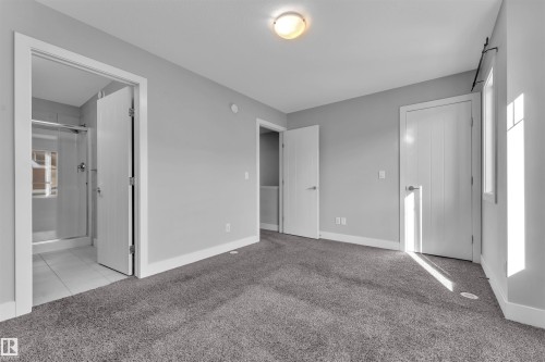 Unfurnished bedroom featuring light carpet and connected bathroom - #38 1508 105 St Nw, Edmonton, AB - Indoor Photo Showing Other Room