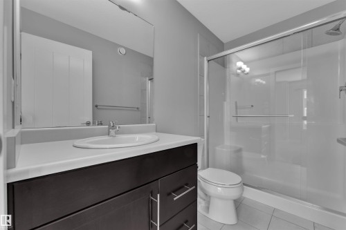 Bathroom featuring vanity, a shower stall, and light tile patterned floors - #38 1508 105 St Nw, Edmonton, AB - Indoor Photo Showing Bathroom