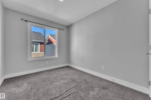 Empty room featuring baseboards and light carpet - #38 1508 105 St Nw, Edmonton, AB - Indoor Photo Showing Other Room