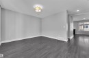 Empty room featuring dark wood-style floors, a fireplace, and recessed lighting - #38 1508 105 St Nw, Edmonton, AB  - Indoor Photo Showing Other Room 