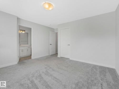 Unfurnished bedroom with light carpet and ensuite bath - 1404 Podersky Link, Edmonton, AB - Indoor Photo Showing Other Room