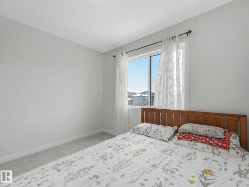 Bedroom with light carpet and baseboards - 1404 Podersky Link, Edmonton, AB - Indoor Photo Showing Bedroom