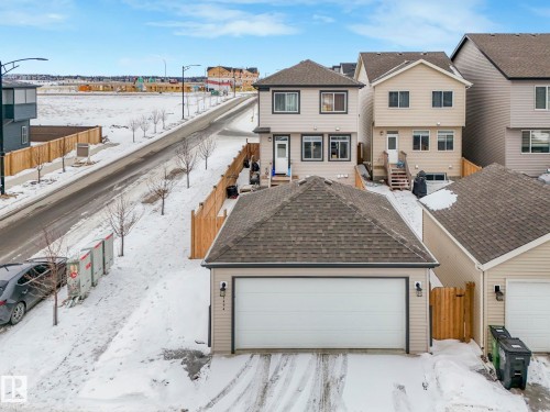 Traditional home featuring a residential view, a gate, and a shingled roof - 1404 Podersky Link, Edmonton, AB - Outdoor