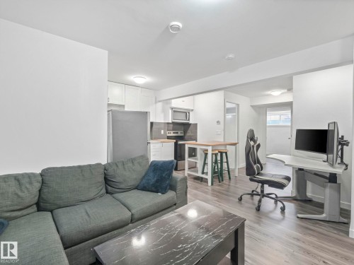 Living area with light wood-style floors and baseboards - 1404 Podersky Link, Edmonton, AB - Indoor Photo Showing Living Room