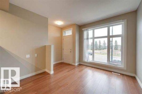 Entryway featuring baseboards and light wood finished floors - 1621 Cunningham Way Sw, Edmonton, AB - Indoor Photo Showing Other Room