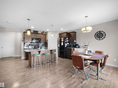 Dining area with light wood-type flooring and a textured ceiling - 1659 Hammond Crescent, Edmonton, AB - Indoor Photo Showing Dining Room