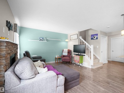 Living room with wood finished floors and a fireplace - 1659 Hammond Crescent, Edmonton, AB - Indoor Photo Showing Other Room With Fireplace