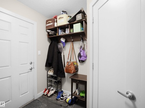 Mudroom featuring a textured ceiling and dark tile patterned floors - 1659 Hammond Crescent, Edmonton, AB - Indoor