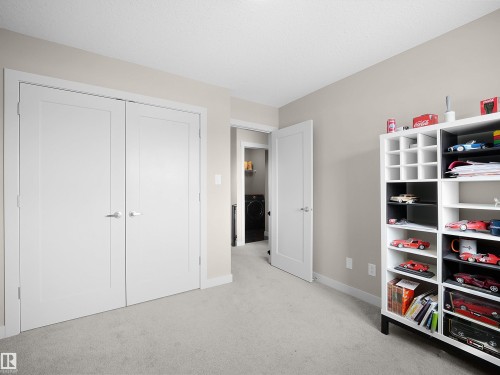 Unfurnished bedroom featuring light carpet, washer / dryer, and a closet - 1659 Hammond Crescent, Edmonton, AB - Indoor Photo Showing Other Room