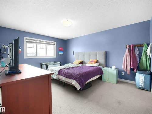 Bedroom with light carpet and a textured ceiling - 1659 Hammond Crescent, Edmonton, AB - Indoor Photo Showing Bedroom