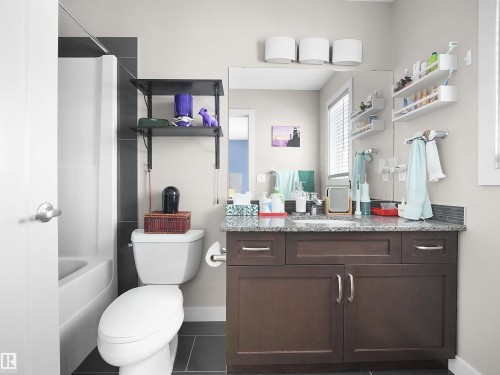 Bathroom with vanity, bathing tub / shower combination, and dark tile patterned floors - 1659 Hammond Crescent, Edmonton, AB - Indoor Photo Showing Bathroom