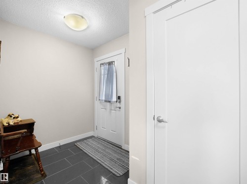 Foyer featuring a textured ceiling and dark tile patterned flooring - 1659 Hammond Crescent, Edmonton, AB - Indoor Photo Showing Other Room