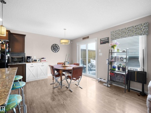 Dining space with a textured ceiling and light wood-type flooring - 1659 Hammond Crescent, Edmonton, AB - Indoor Photo Showing Other Room With Fireplace