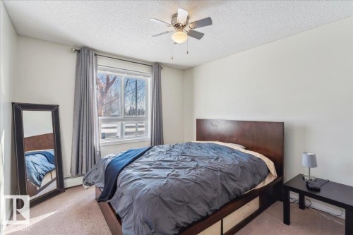 Bedroom featuring carpet, a textured ceiling, ceiling fan, and a baseboard radiator - 112 5340 199 Street, Edmonton, AB - Indoor Photo Showing Bedroom