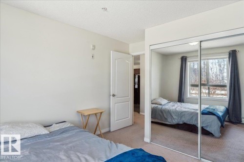 Bedroom featuring light carpet, a textured ceiling, and a closet - 112 5340 199 Street, Edmonton, AB - Indoor Photo Showing Bedroom