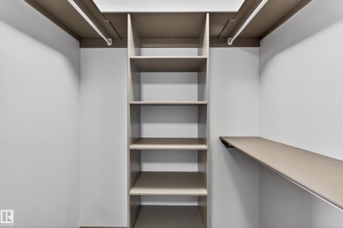 The property includes a closet with built-in shelving and hanging rods for storage - 1649 Cunningham Way, Edmonton, AB - Indoor With Storage