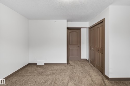 This room features light-colored walls, brown trim, and wall-to-wall carpeting - 1649 Cunningham Way, Edmonton, AB - Indoor Photo Showing Other Room
