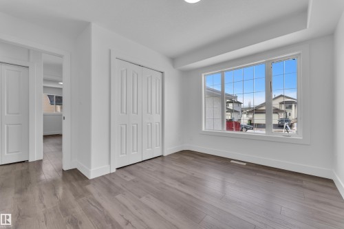 Unfurnished bedroom with a closet, multiple windows, and light wood-style flooring - 6741 162A Avenue, Edmonton, AB - Indoor Photo Showing Other Room