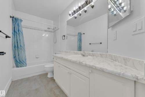 Bathroom with vanity, shower / bath combo, and light tile patterned floors - 6741 162A Avenue, Edmonton, AB - Indoor Photo Showing Bathroom