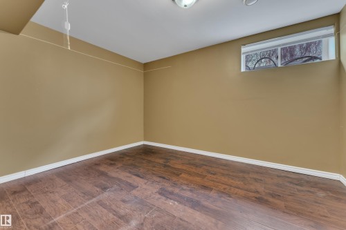 Empty room with dark wood-style floors and baseboards - 6741 162A Avenue, Edmonton, AB - Indoor Photo Showing Other Room