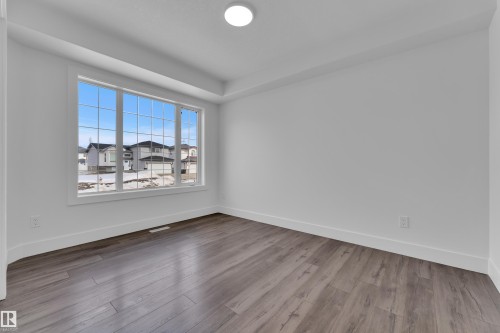 Empty room featuring baseboards and dark wood-type flooring - 6741 162A Avenue, Edmonton, AB - Indoor Photo Showing Other Room