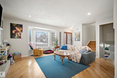 Living room with light wood finished floors, a textured ceiling, and recessed lighting - 9221 84 Street, Fort Saskatchewan, AB - Indoor Photo Showing Living Room