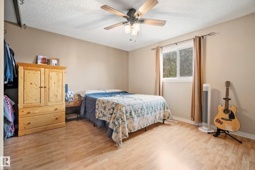 Bedroom featuring light wood-style floors, a textured ceiling, and a ceiling fan - 9221 84 Street, Fort Saskatchewan, AB - Indoor Photo Showing Bedroom