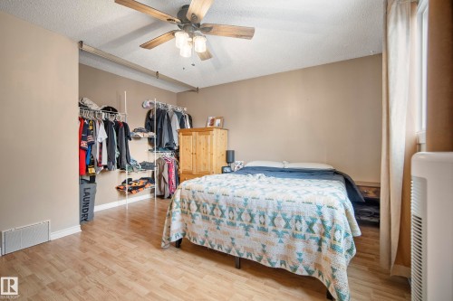 Bedroom with light wood-type flooring, a textured ceiling, a closet, and ceiling fan - 9221 84 Street, Fort Saskatchewan, AB - Indoor Photo Showing Bedroom