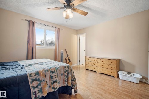 Bedroom featuring light wood finished floors, ceiling fan, and a textured ceiling - 9221 84 Street, Fort Saskatchewan, AB - Indoor Photo Showing Bedroom