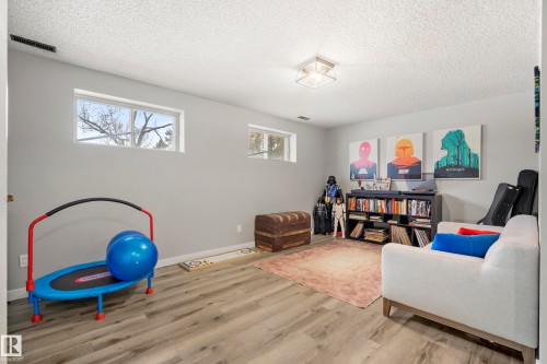 Living area featuring wood finished floors and a textured ceiling - 9221 84 Street, Fort Saskatchewan, AB - Indoor