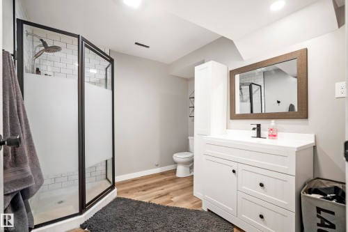 Bathroom featuring vanity, a stall shower, and light wood-style flooring - 9221 84 Street, Fort Saskatchewan, AB - Indoor Photo Showing Bathroom