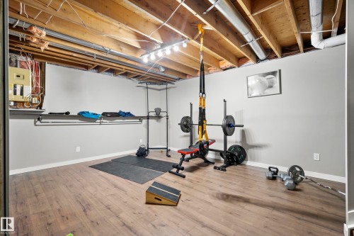 Exercise area with light wood-type flooring and electric panel - 9221 84 Street, Fort Saskatchewan, AB - Indoor Photo Showing Gym Room