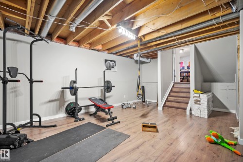 Workout area with light wood-type flooring and baseboards - 9221 84 Street, Fort Saskatchewan, AB - Indoor Photo Showing Gym Room