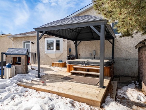 Snow covered patio featuring a gazebo, a hot tub, and a wooden deck - 9221 84 Street, Fort Saskatchewan, AB - Outdoor With Deck Patio Veranda With Exterior