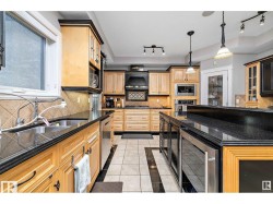 Kitchen featuring beverage cooler, light tile patterned floors, light wood finish cabinets, inlaid floor details, and tasteful backsplash - 
