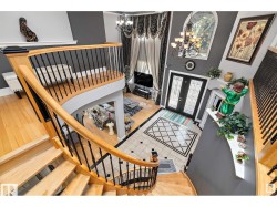 Foyer with a chandelier, light wood-style floors, french doors, and a high ceiling - 