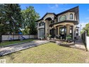 View of front of home with a fenced backyard, a playground, stucco siding, and a patio - 9544 154 Street, Edmonton, AB 