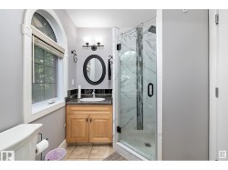 Full bathroom with vanity, a marble finish shower, and light tile patterned flooring - 