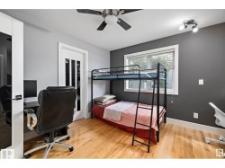 Bedroom featuring a desk, a ceiling fan, and light wood-style flooring - 