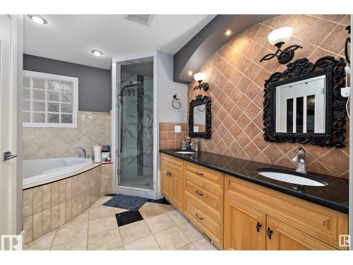 Full bathroom featuring double vanity, a garden tub, a stall shower, and light tile patterned floors - 9544 154 Street, Edmonton, AB 