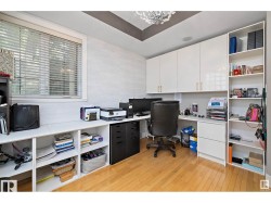 Office space with light wood-style floors and built in desk - 