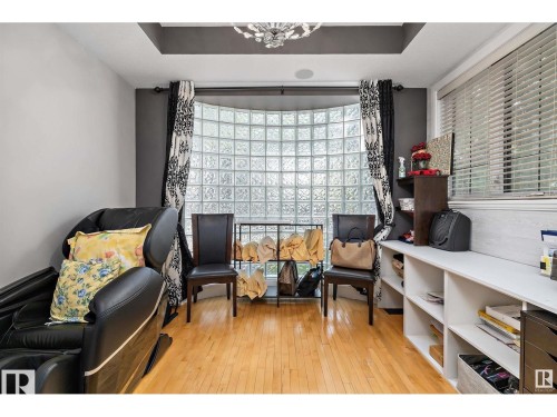 Living area featuring a raised ceiling, light wood-style floors, and healthy amount of natural light - 9544 154 Street, Edmonton, AB 